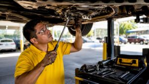 Mechanic inspecting DSG transmission under SUV