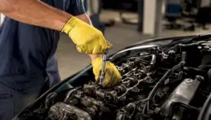 Technician installing spark plugs in engine