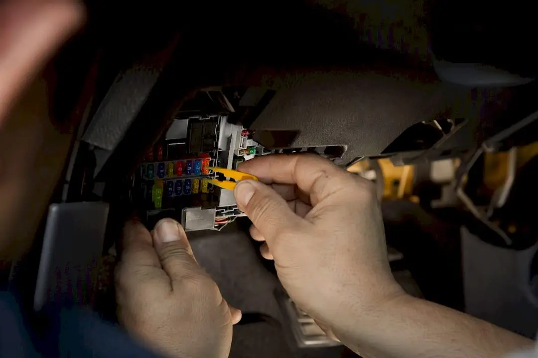 Hands removing windshield wiper fuse from fuse box