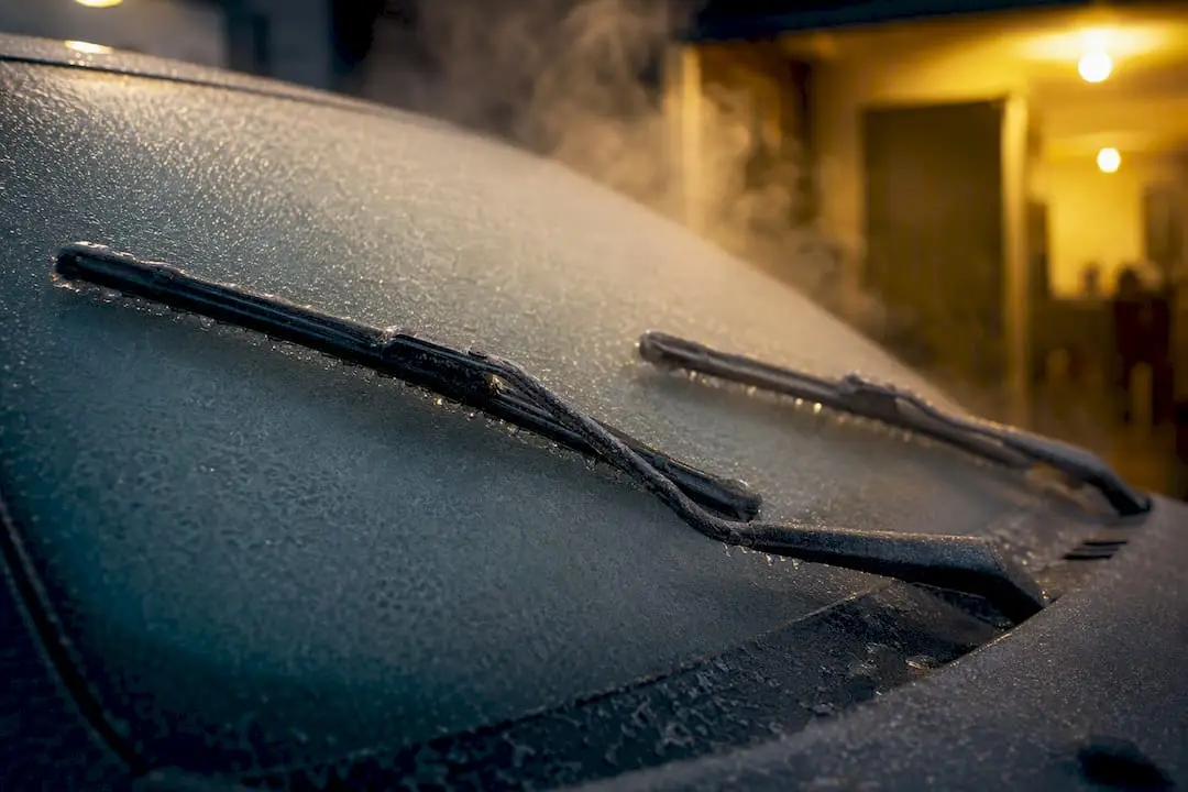 Frozen windshield wiper arms stuck to icy windshield