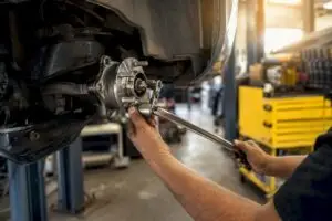 Technician hands removing wheel bearing assembly