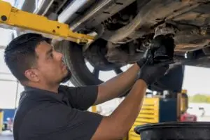 Technician loosening truck oil drain plug