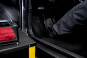 Technician performing brake pedal hold test