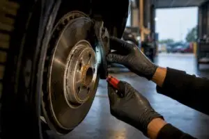Technician inspecting an anonymous vehicle brake