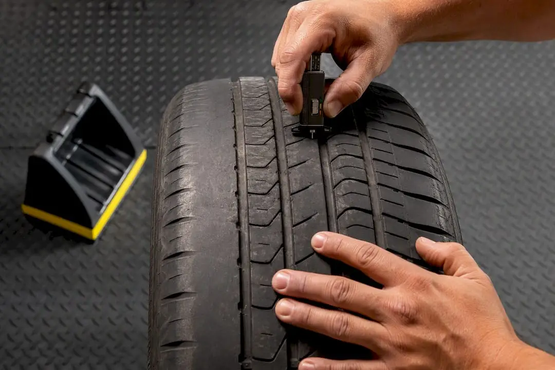 Technician checking uneven tire tread wear