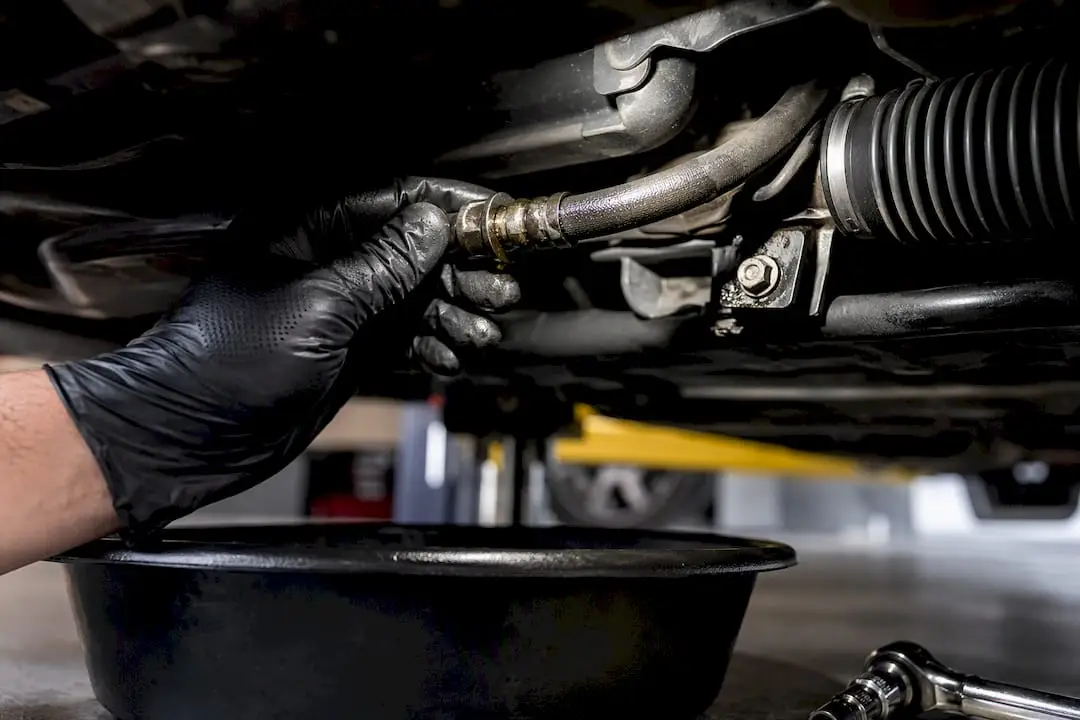Technician inspecting power steering hose