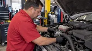 Mechanic inspecting a vehicle thermostat housing