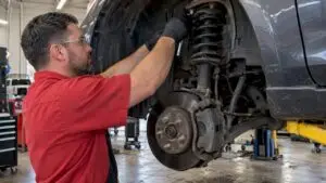 Technician inspecting strut mounting hardware